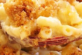 Macro view of a creamy spoonful of homemade mac and cheese being served.