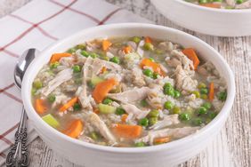 angled shot of carcass turkey soup in bowl with peas and carrots 