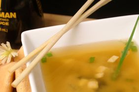 high view of miso soup with a fortune cookie and chopsticks