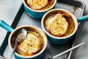 a high angle view of three bowls of French onion soup fresh out of the oven on a baking sheet