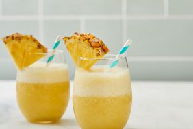 low angle looking at two glasses of pineapple and banana smoothies, garnished with pineapple slices 