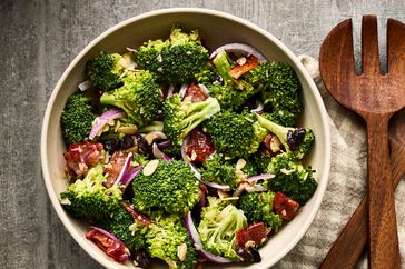 an overhead, close up view of fresh broccoli salad with red onions and broccoli in a bowl 