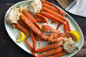 overhead view of crab legs with garlic butter sauce and a few lemon wedges
