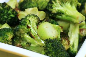 close up view of roasted broccoli in a white bowl