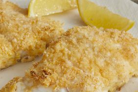 mid angle looking at a fillet of crispy baked walleye will a fork-full taken off
