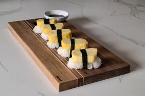 Japanese tamago egg served with sushi rice and dipping sauce on a wooden board