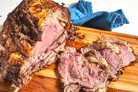 close up view of sliced prime rib on a wooden cutting board 