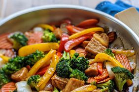 colorful chicken stir fry in a stainless steel skillet