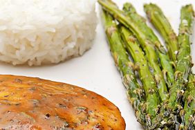 close up view of Baked Honey Mustard Chicken on a plate with rice and asparagus
