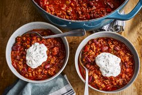 a high angle view of two bowls of the best damn chili each topped with a dollop of sour cream.