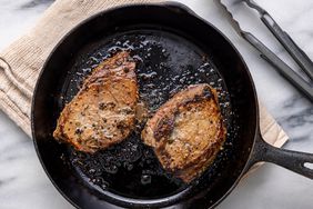 an overhead view of two steaks perfectly seared in a cast iron skillet
