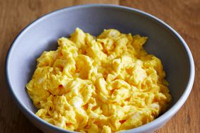 close up view of a blue bowl with scrambled eggs