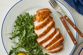 looking down at an air fryer pork chop all sliced, with a side of fresh greens