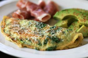 close up view of a Baby Spinach Omelet, avocado slices and mean on a plate