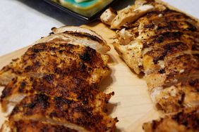 close up view of sliced Blackened Chicken on a wooden cutting board