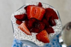 closeup of clear glass parfait dish with chia seed pudding and red berries