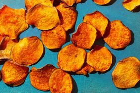 air fryer sweet potato chips on a blue surface. 