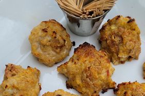 Baked chicken meatballs on white plate with steel cup of toothpicks