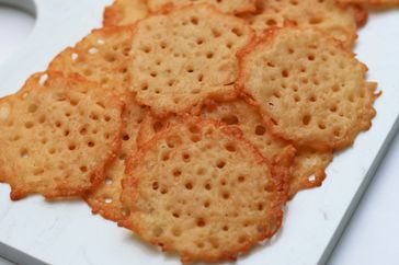 Golden toasted cheese crisps on a white platter