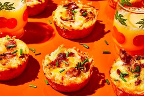 Hash brown and bacon omelet cups on a bright orange surface. 