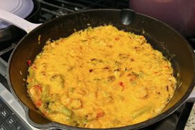 iron skillet with cheesy casserole-style dish on the stove