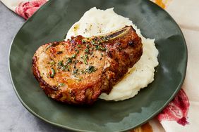 a cast iron cooked pork chop served over mashed potatoes. 