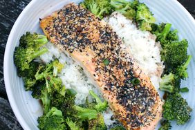 salmon filet coated in everything bagel seasoning over rice with broccoli in white bowl