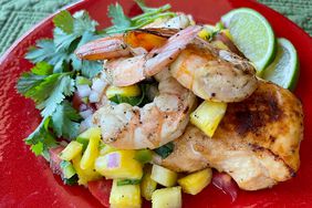 grilled chicken, shrimp, and pineapple pico de gallo with cilantro and lime on red plate