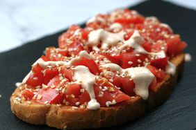 chopped tomatoes on toast with everything bagel seasoning and sriracha mayo drizzle
