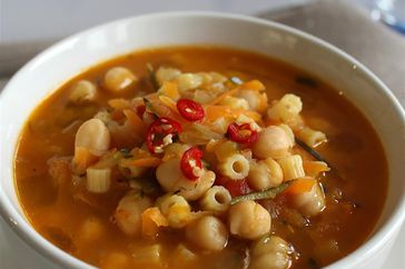 white bowl of chickpea and pasta stew in a tomato broth