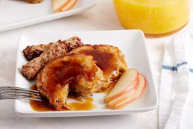 Apple fritter pancakes served with apple slices and sausage.