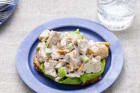 a close up view of basic chicken salad served open faced on a piece of bread with lettuce