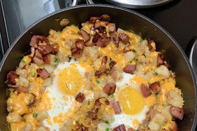 close up view of a Loaded Breakfast Skillet in a cast iron skillet on a stove