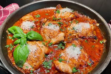 skillet with chicken things in a tomato sauce with Parmesan and basil