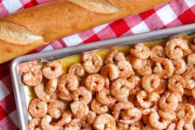 shrimp on baking sheet with sauce and baguette